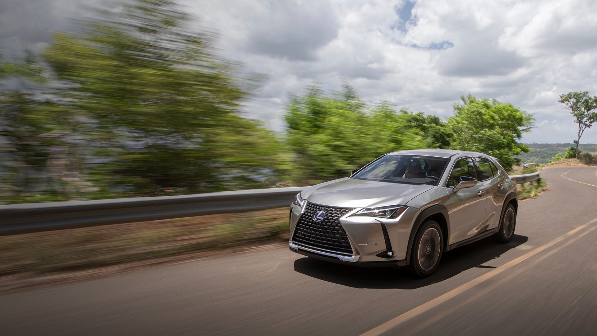 Silver Lexus UX being driven on the road.