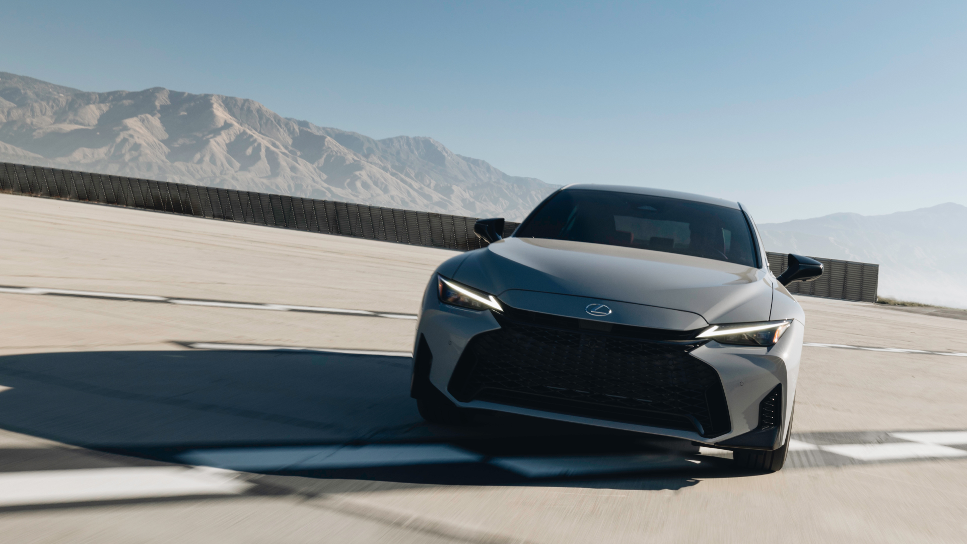 Silver Lexus IS parked in front of two pillars